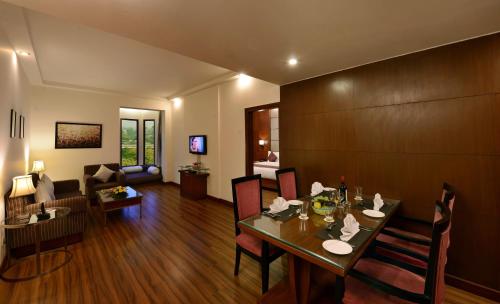 a living room with a dining table and a couch at Lords Plaza Jaipur in Jaipur