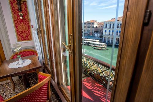 a door to a balcony with a view of a river at Antica Locanda Sturion Residenza d'Epoca in Venice