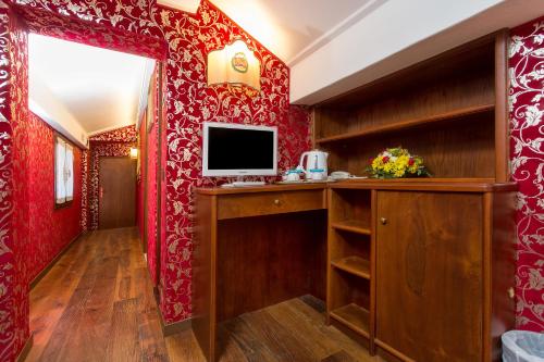 a room with red walls and a television on a desk at Antica Locanda Sturion Residenza d'Epoca in Venice