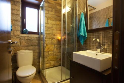 a bathroom with a toilet and a sink and a shower at Parathalasso Villas in Monastiraki