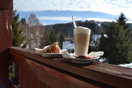 een drankje en twee borden eten op een rail met uitzicht bij Apartmán Anežka Albrechtice in Albrechtice v Jizerských horách