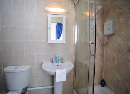 a bathroom with a toilet and a sink and a shower at Lynmoore Guest House in Blackpool