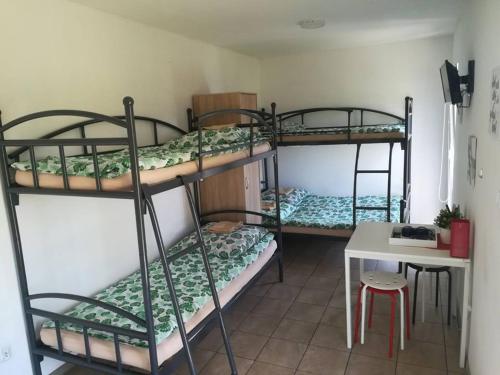 Schlafsaal mit 4 Etagenbetten und einem Tisch in der Unterkunft Domki całoroczne in Zator