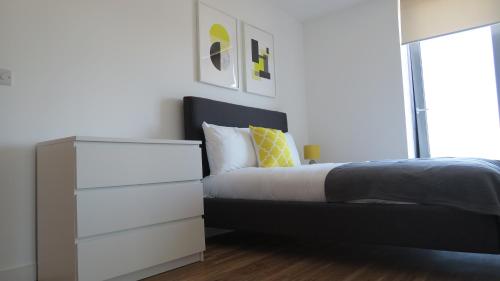 
a bedroom with a bed and a dresser at Quay Apartments in Manchester
