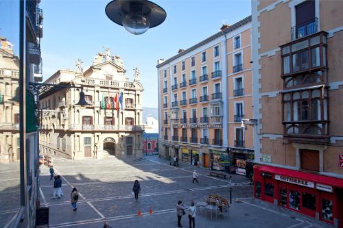 a group of people walking around a city street at Hotel Pompaelo Plaza del Ayuntamiento & Spa in Pamplona