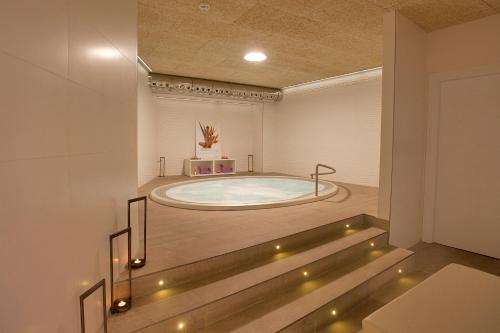 una gran bañera de hidromasaje en una habitación con luces en Hotel Pompaelo Plaza del Ayuntamiento & Spa, en Pamplona