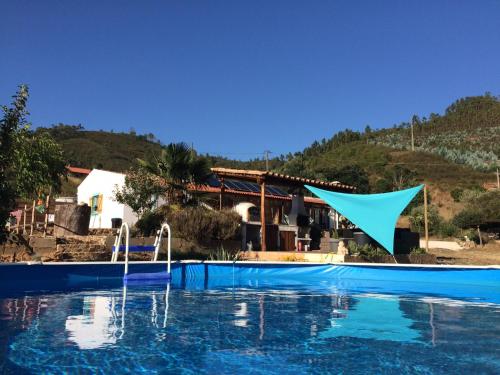 a swimming pool with a blue flag in front of a house at Nova Alofa holiday home in Monchique