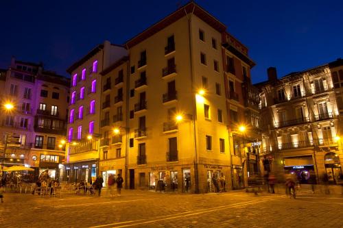 a group of buildings on a street at night at Hotel Pompaelo Plaza del Ayuntamiento & Spa in Pamplona