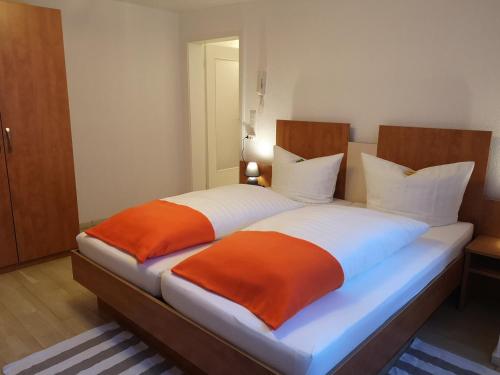 een slaapkamer met 2 bedden met oranje en witte lakens bij Altstadt in Oberhausen