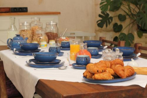 un tavolo con ciotole blu e piatti di cibo di Le Chaton Rouge a Saint-Pierre-du-Lorouër