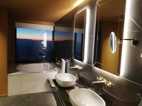 a bathroom with two sinks and a large window at Grand Hotel San Marino in San Marino