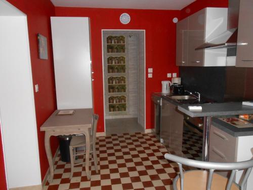 a kitchen with red walls and a checkered floor at gite du vivier 2km du parc beauval in Seigy