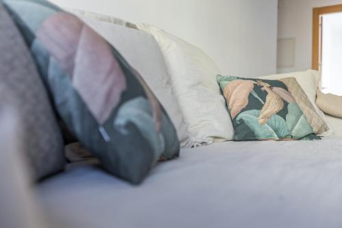 un sofá con tres almohadas encima en Horoko Apartments by gaiarooms en Madrid