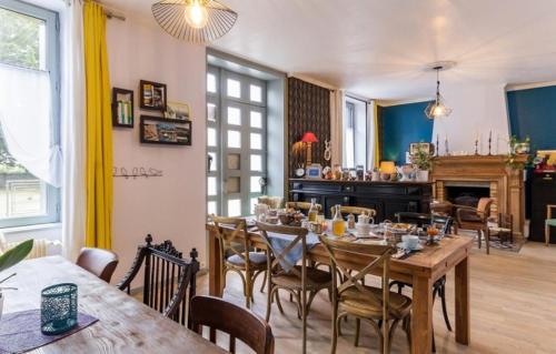 een eetkamer met een houten tafel en stoelen bij La Maison Bizienne Guérande in Guérande