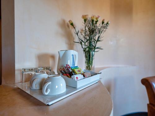 a table with two tea pots and a vase with flowers at Active Hotel Paradiso in Peschiera del Garda