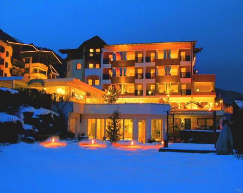 a large building in the snow at night at Alpenhotel Stefanie in Mayrhofen