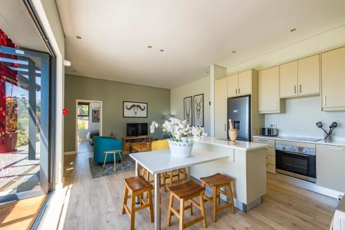 uma cozinha e sala de estar com mesa e cadeiras em Kunjani Villas em Stellenbosch
