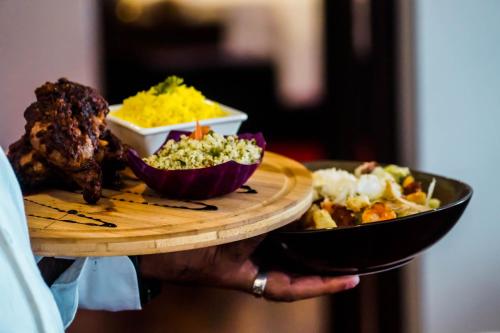 a person holding a tray with a plate of food at Trillium Boutique City Hotel in Colombo