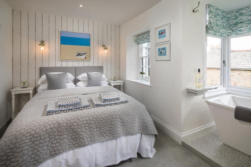 um quarto com uma cama grande e uma banheira em Penwyth House em Newquay