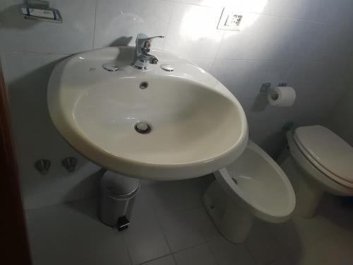 a white bathroom with a sink and a toilet at Hotel Colombo in Marghera
