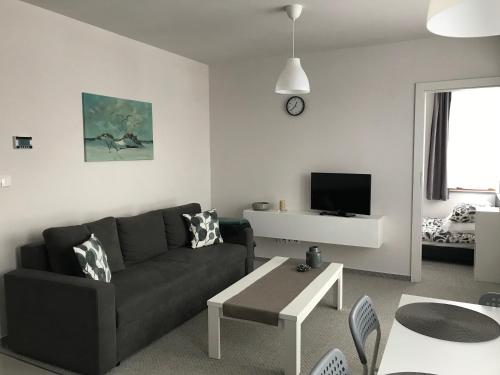 a living room with a couch and a table at Apartament koloru morza - Turkus in Łeba