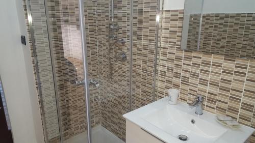 a bathroom with a glass shower and a sink at B&B Inn Centro in Cosenza