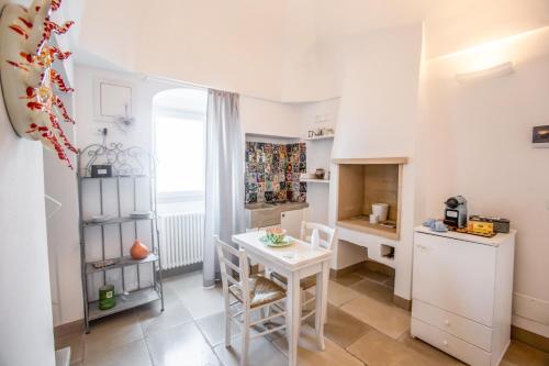 a small kitchen with a table and a refrigerator at Dimore del TEMPO PERS0 Mare videre in Ostuni