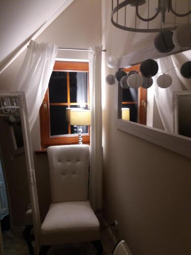 a chair in a room with a window and a lamp at Domek w Karkonoszach in Przesieka