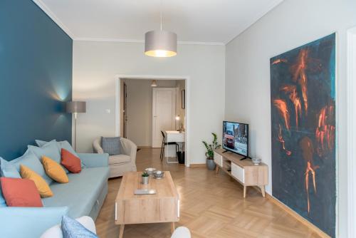 a living room with a blue couch and a table at DARSISS 2 - Museum Apartment in Athens