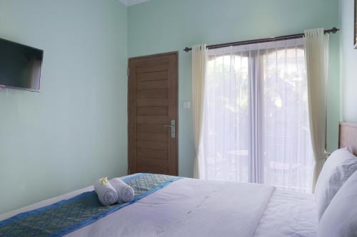 a bedroom with a bed with two towels on it at Astana House in Ubud
