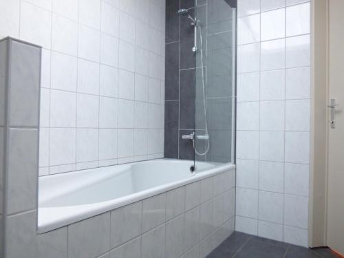 La salle de bains est pourvue d'une baignoire et d'une douche. dans l'établissement De Alpacaboerderij, à Bocholt