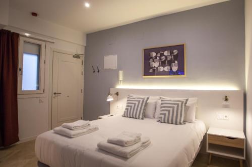 a bedroom with a white bed with towels on it at Gran Central Suites in Madrid