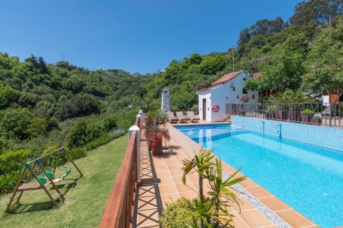 a villa with a swimming pool and mountains in the background at Finca Casas Nanitas in Moya