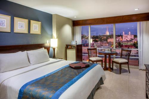a hotel room with a bed and a view of a city at Hodelpa Centro Plaza in Santiago de los Caballeros