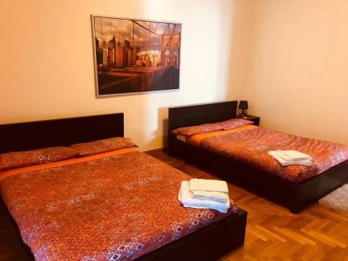 a room with two beds and a painting on the wall at Ca’Melia B&B in Arconate