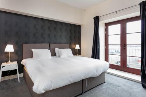 um quarto com uma cama grande e uma janela grande em Granary Suite No3 - Donnini Apartments em Ayr