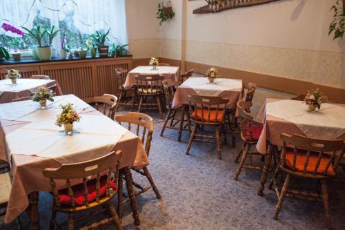 a room with tables and chairs with flowers on them at Frühstückspension Kölich in Klagenfurt
