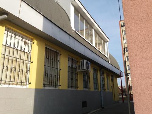 a yellow and white building with barred windows at Hradna 9a in Nové Zámky