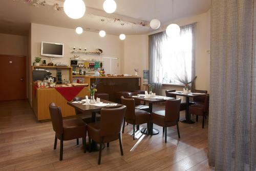a restaurant with tables and chairs in a room at Hotel Edvards in Riga