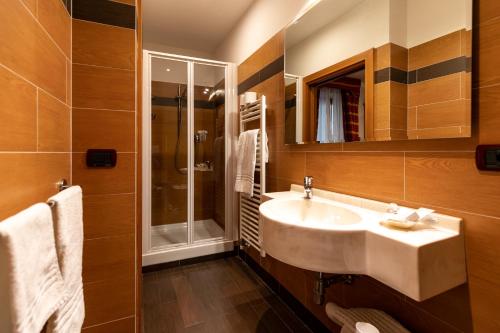 a bathroom with a sink and a shower at Hotel Isolabella Wellness in Fiera di Primiero