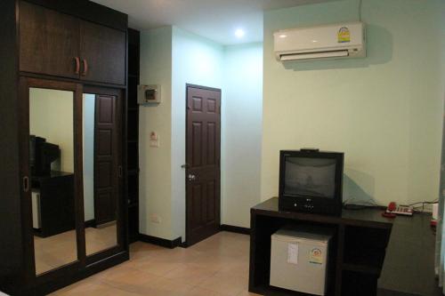 a room with a tv and a hallway with a door at Baan Vor. Sumongkol Service Apartment in Khon Kaen
