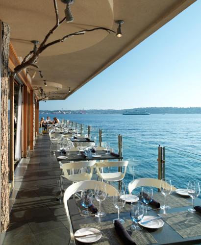 a row of tables on a pier with the water at The Edgewater, a Noble House Hotel in Seattle
