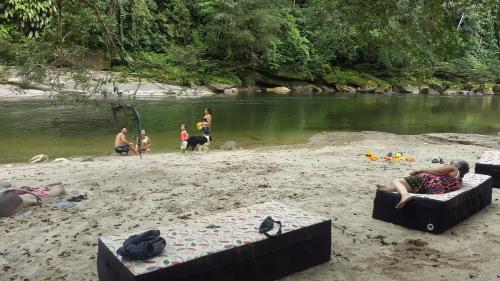 eine Gruppe von Menschen an einem Strand in der Nähe eines Flusses in der Unterkunft PlayaSelva EcoLodge in Archidona
