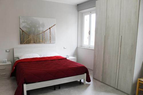 um quarto com uma cama com um cobertor vermelho em I Pini house in the heart of the city em Pisa