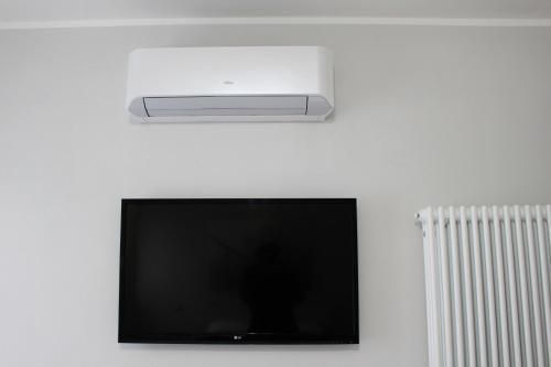 a flat screen tv hanging on a white wall at I Pini house in the heart of the city in Pisa