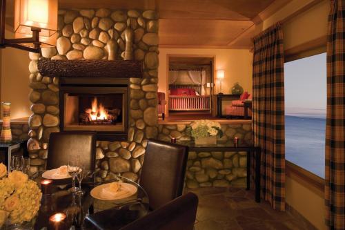 a living room with a fireplace and a table and chairs at The Edgewater, a Noble House Hotel in Seattle