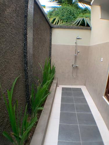 a bathroom with a shower in a wall at Dalai Home in Kuta Lombok