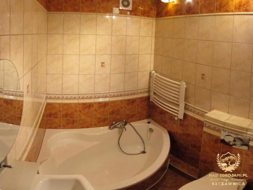 łazienka z wanną, toaletą i umywalką w obiekcie "Nad Zdrojami" Domek Sopotnicka 691-739-603 w mieście Szczawnica