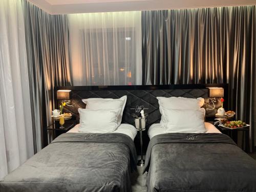 dos camas sentadas una al lado de la otra en una habitación en Hotel Fado, en Gorzów Wielkopolski