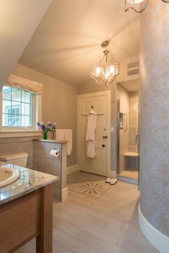 a bathroom with a white robe hanging on the door at Gothic Eves Inn and Spa Bed and Breakfast in Trumansburg
